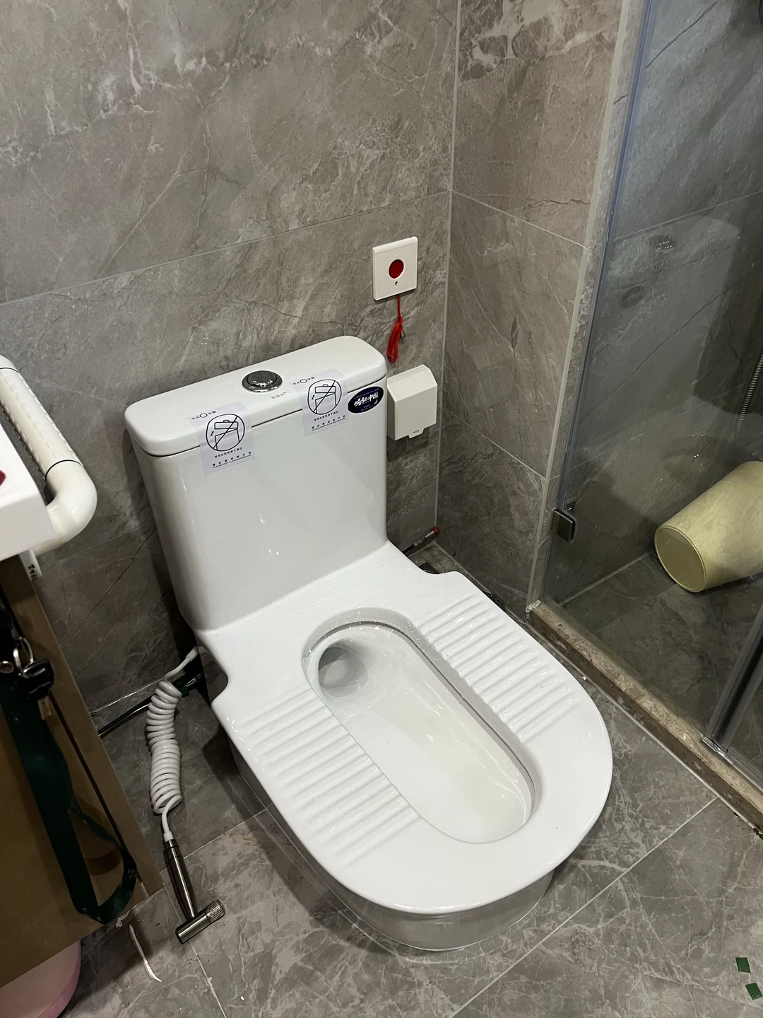 灰墙淋浴空间内安装完成的台式蹲便器，仅供空间布局参考